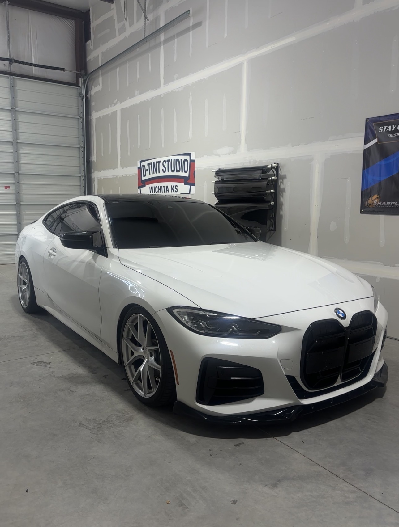 White BMW with freshly tinted windows inside the D Tint Studios Wichita shop
